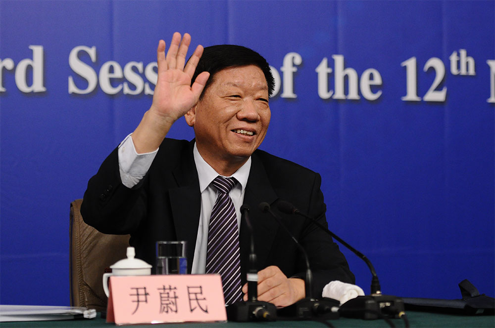 人社部部长尹蔚民在会前向记者挥手致意